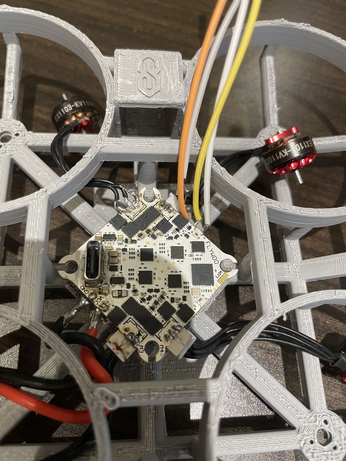 Close-up of the all-in-one flight controller board mounted in the center of the drone frame